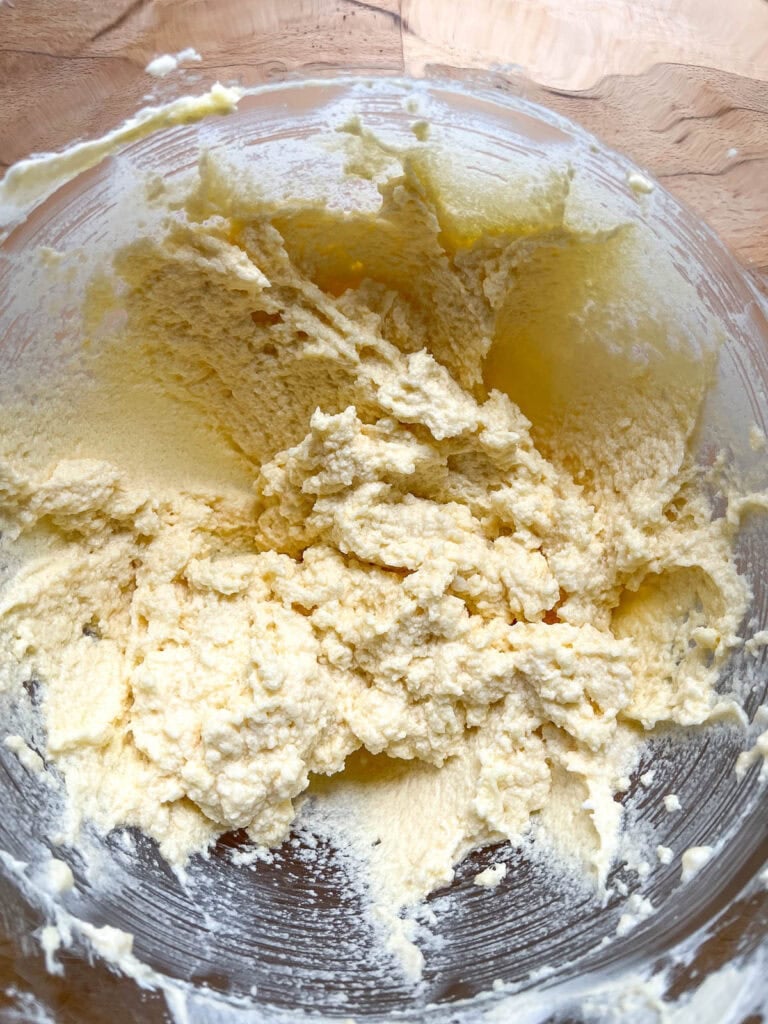 Eggs, sour cream and vanilla beaten into butter and sugar mixture in the bowl of electric stand mixer.