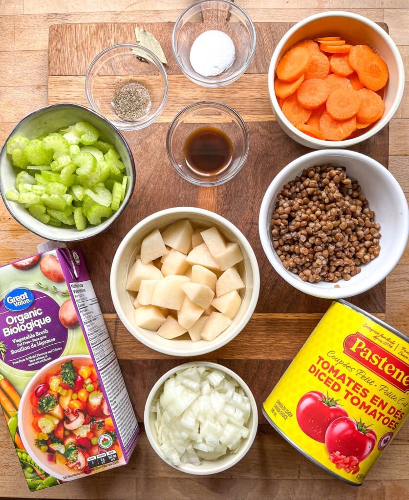 Ingredients to make Autumn Vegetable soup including canned tomatoes, vegetable broth, potatoes, chopped celery, sliced carrots, lentils and spices.