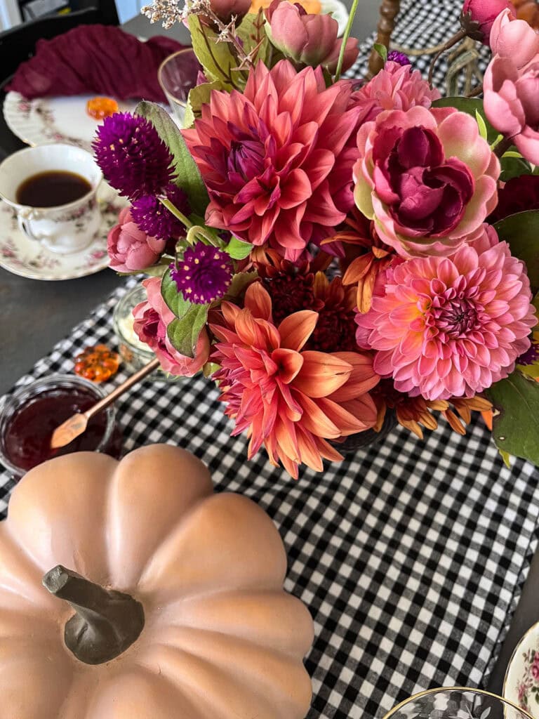 A floral centrepiece made with dark and moody coloured dahlias.